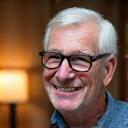 Portrait of Thomas, a sharp senior man engrossed in reading in a cozy setting.